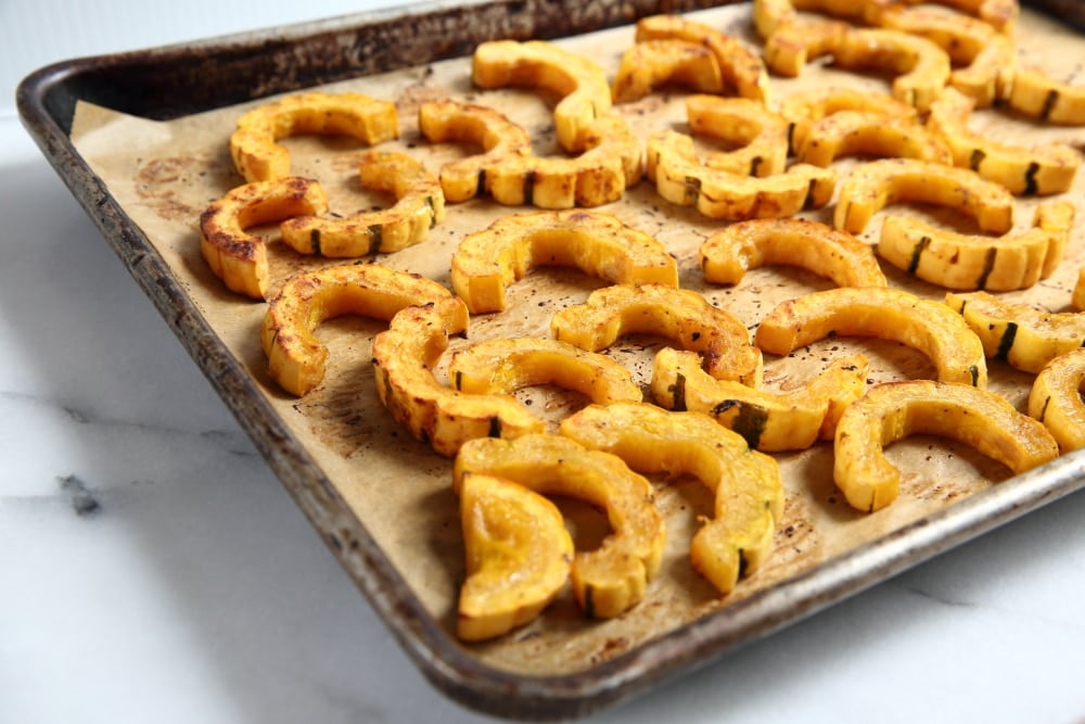 Roasted Delicata squash rings on a baking sheet.