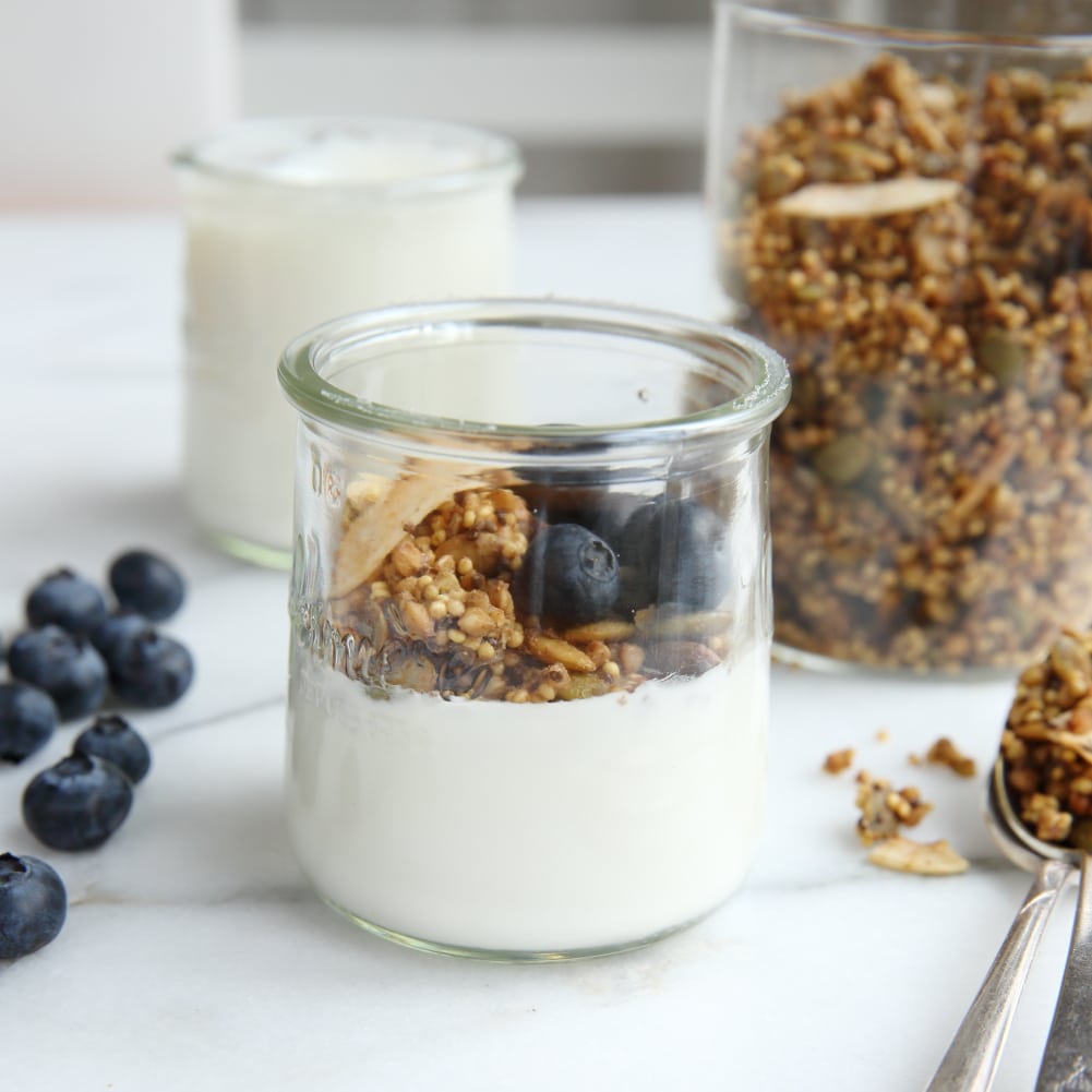 Millet granola in jar with yogurt and blueberries