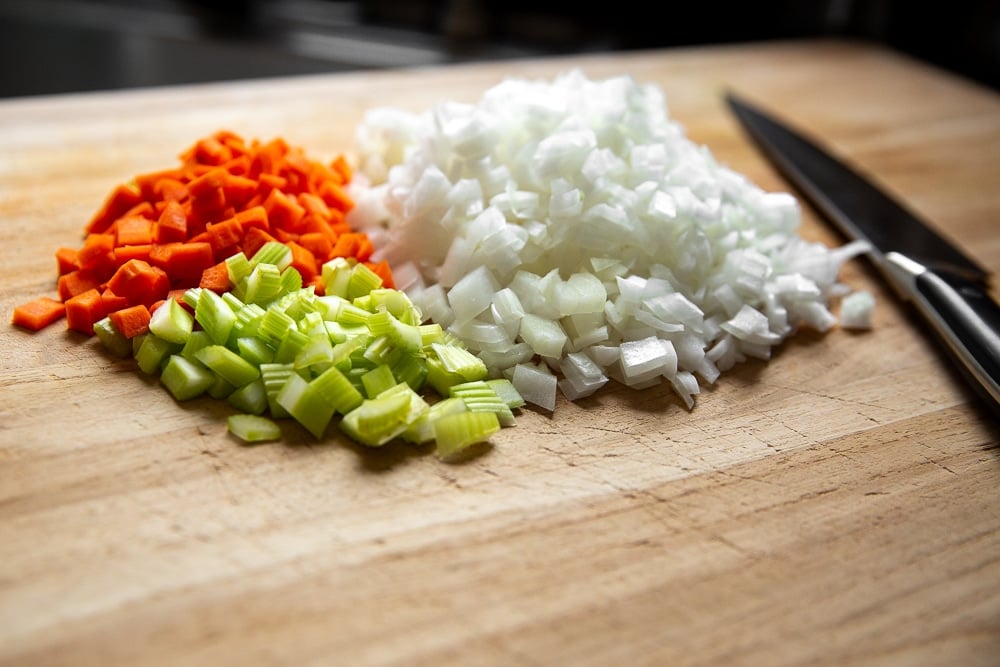 Process shot showing finely chopped onions, carrots and celery for the ragu