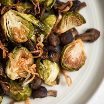 Caramelized Brussels sprouts with mushrooms and fried shallots on platter