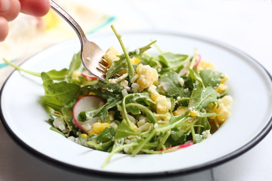 Close up of fork taking bite of Mexican street corn salad.