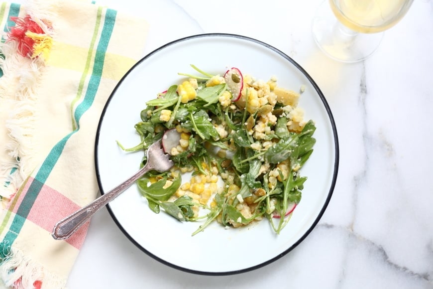 Overhead shot of half-eaten plate of Mexican street corn salad.