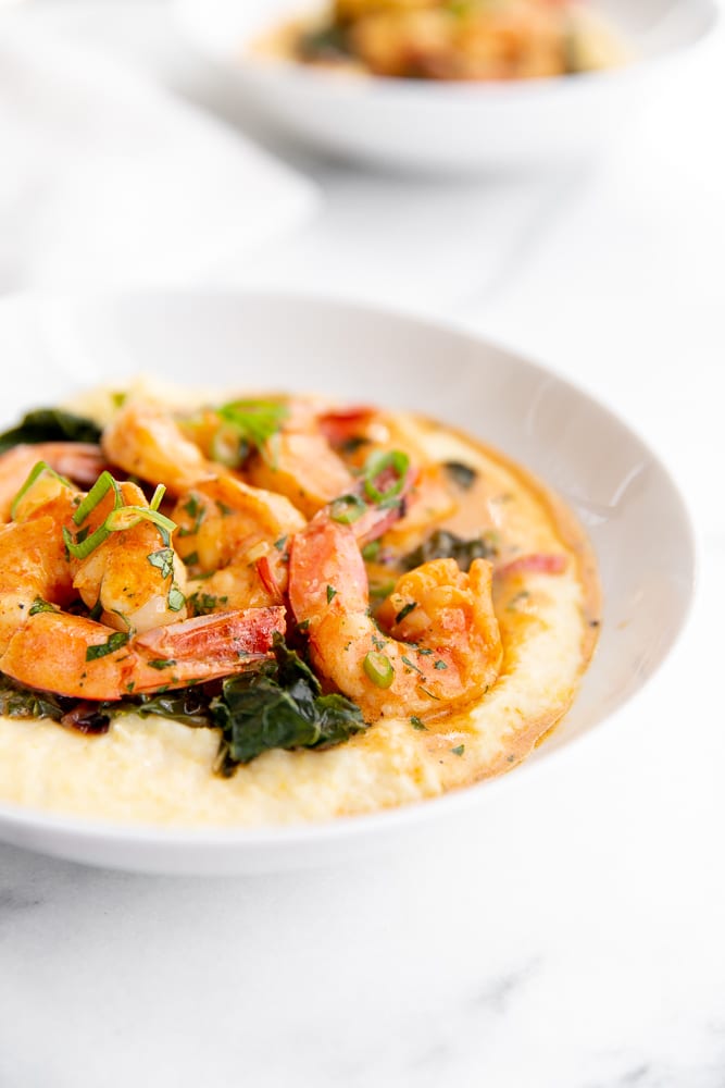 Coconut sriracha shrimp and kale over grits in serving bowl