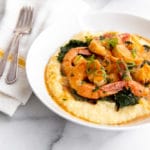 Coconut sriracha shrimp and kale in bowl over grits