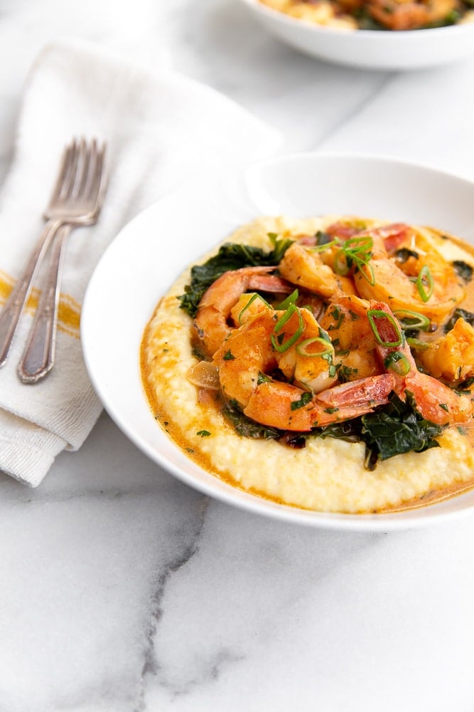 Coconut sriracha shrimp and kale in bowl over grits 