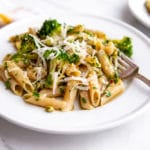 Broccoli pasta on plates with fork and napkin in the background