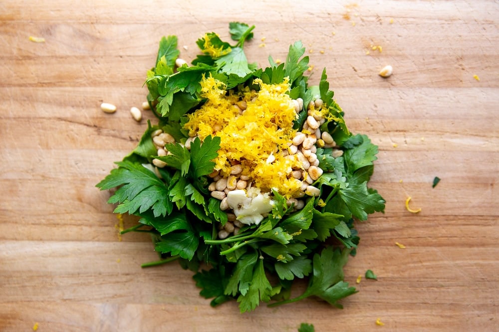 Parsley, pine nuts, lemon zest and garlic piled on cutting board for the gremolata, to sprinkle over the broccoli pasta