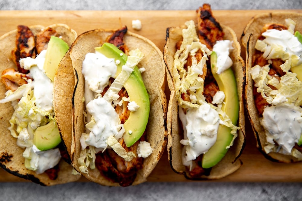 Easy chipotle chicken recipe in tacos on cutting board