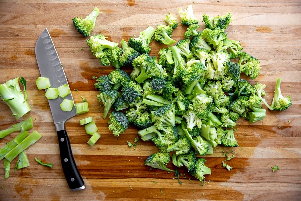 Chopped broccoli on cutting board with knife for the broccoli pasta