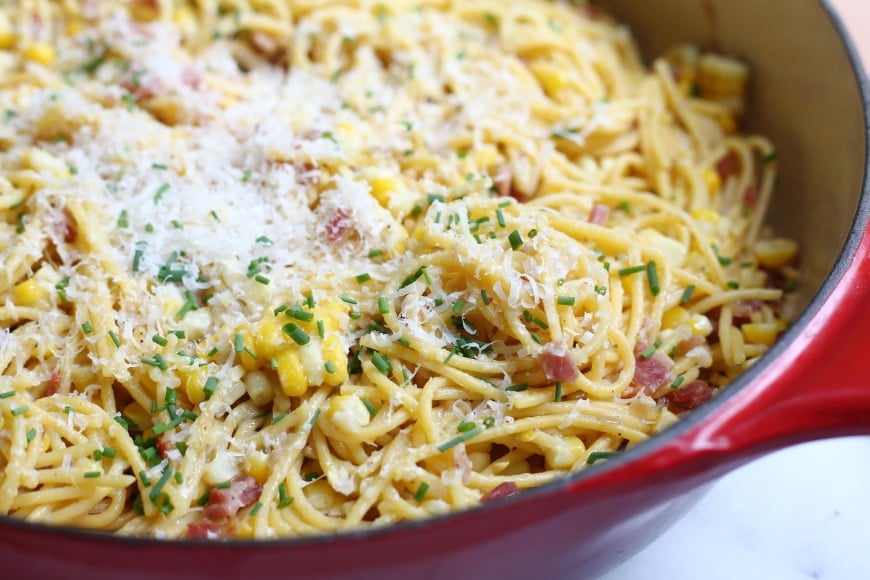 Close up of spaghetti with corn and bacon in a skillet