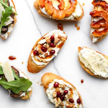 Assortment of whipped ricotta crostini on countertop