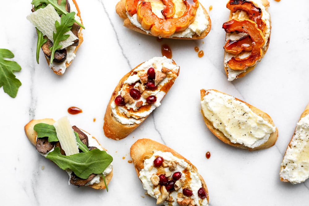 Assortment of whipped ricotta crostini on countertop