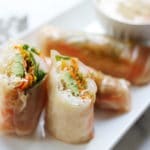 Side-view of shrimp winter rolls lined up on a serving platter.