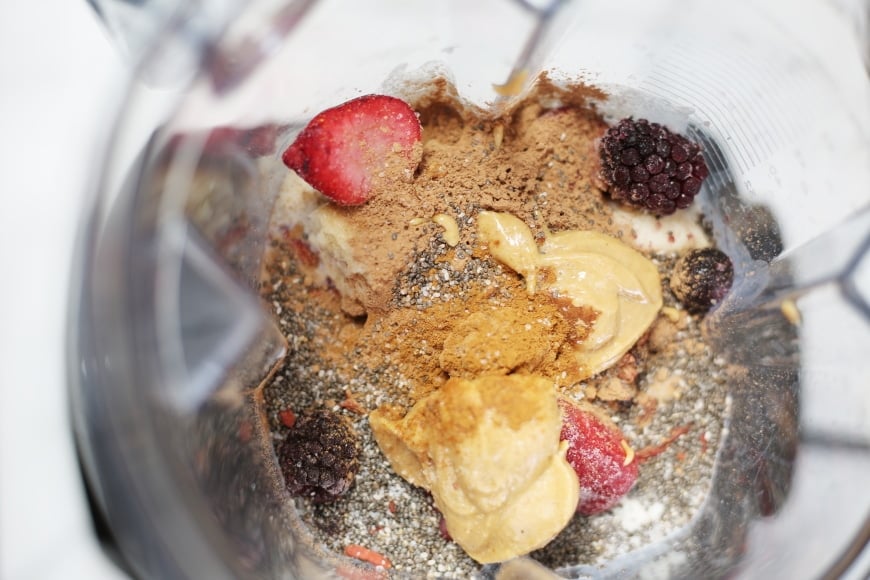 Ingredients for the superfood berry smoothie bowl in the blender container before blending