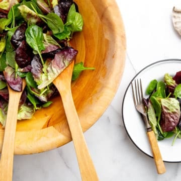 A simple French green salad in a wood bowl.
