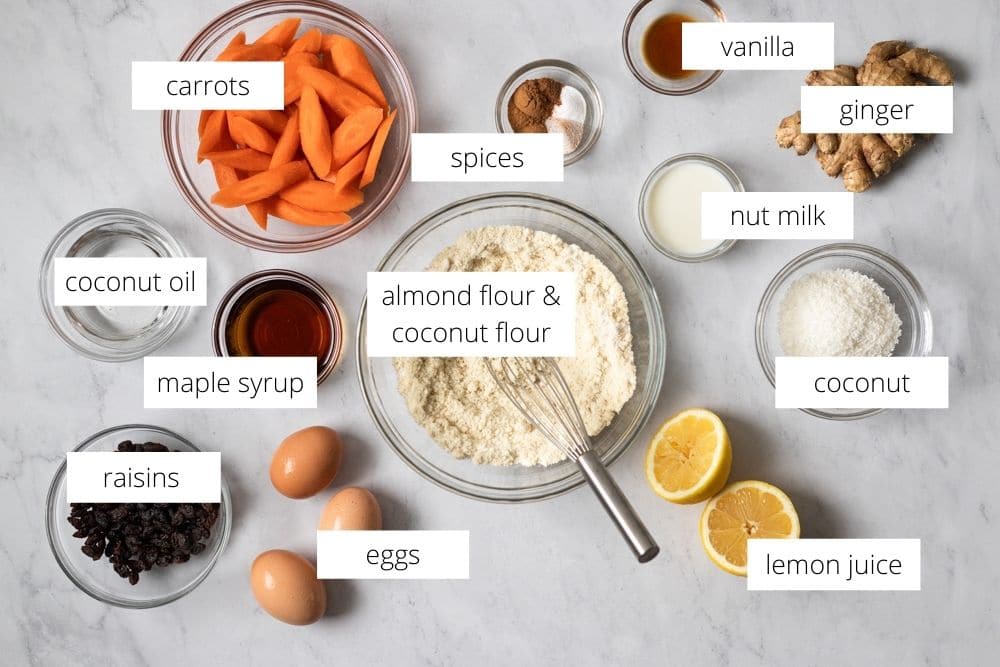 All of the ingredients for the carrot cake muffins arranged on a work surface and labeled.