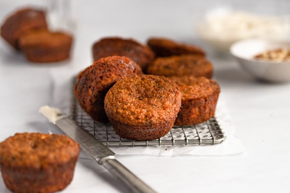 Paleo carrot cake muffins on a cooling rack. 