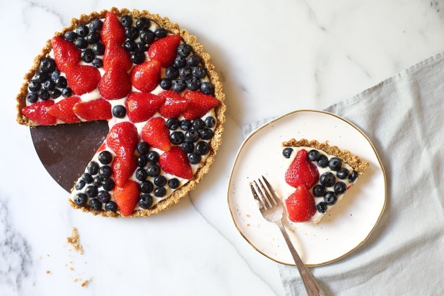 Overhead shot of the berry tart, with a slice on a plate. 