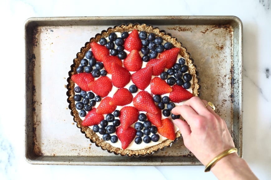 Process shot showing the final berries going on top of the gluten free berry tart.