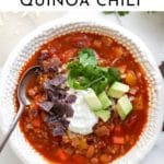 Bowl of vegetable and quinoa chili with toppings.