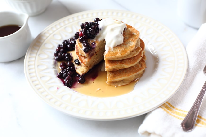 Banana Oat Blender Pancakes on plate with syrup and blueberries
