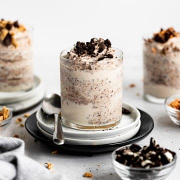A homemade blizzard in a serving glass with crushed cookies alongside.
