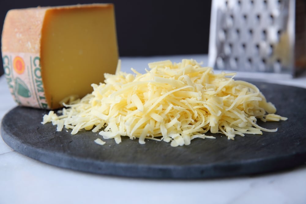 Shredded Comte cheese on a slate board.  