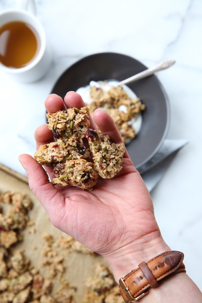 granola clusters recipe in hand with bowl in background