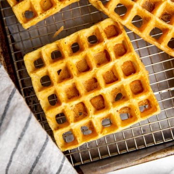 Chickpea waffles lined up on cooling rack set over sheet pan