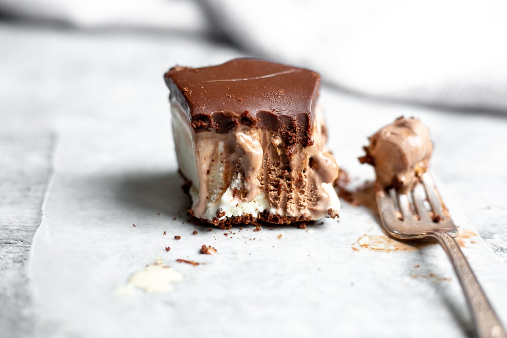 Half-eaten slice of easy ice cream pie on wax paper with fork