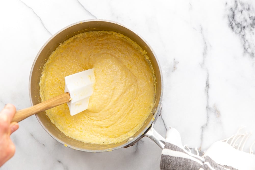 Spatula stirring grits in a saucepan