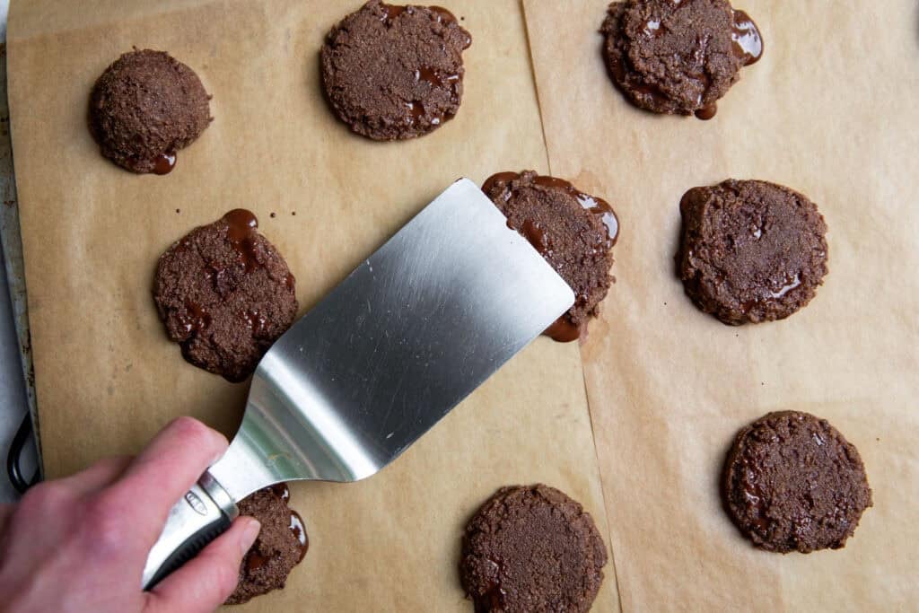 Freshly baked gluten free chocolate cookies cooling on a baking sheet