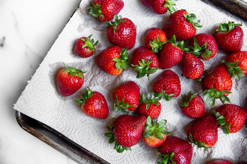 Washed strawberries spread out on paper towels to dry