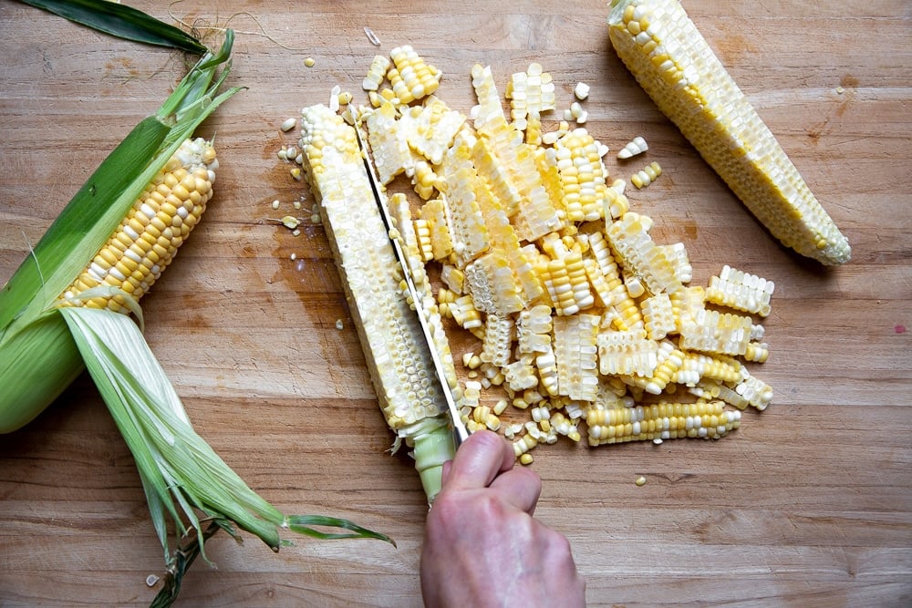 Process shot showing how to cut corn kernels off the cob.