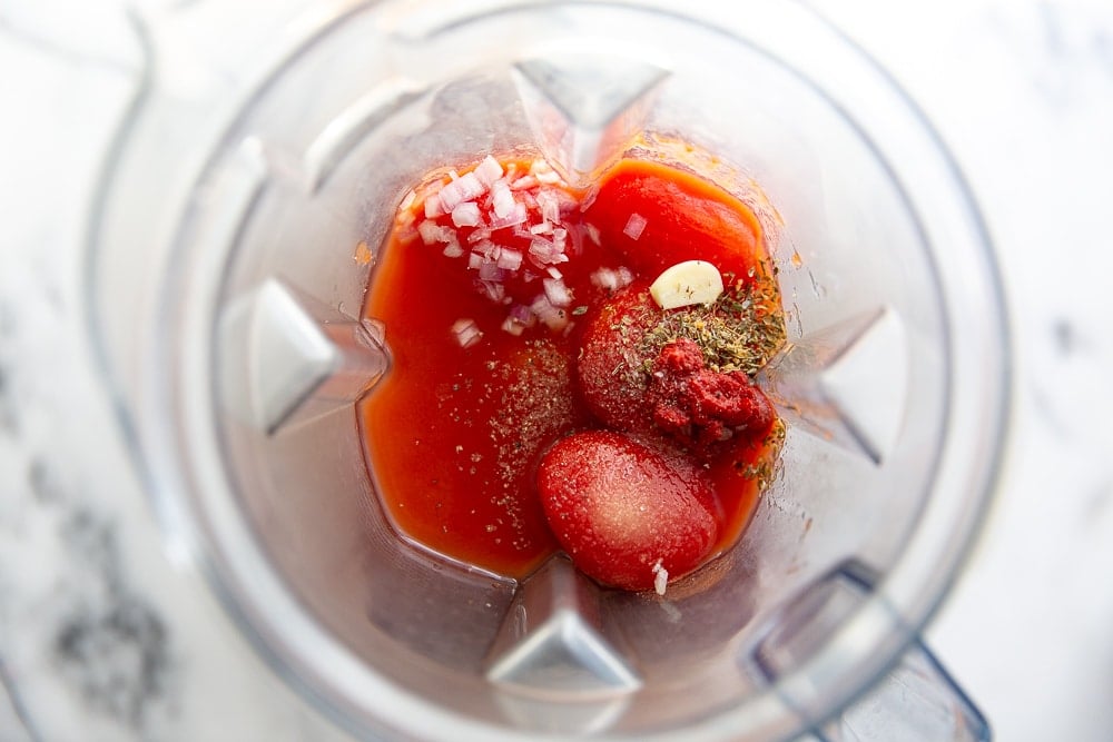 Process shot showing the tomato soup ingredients in a Vitamix blender.