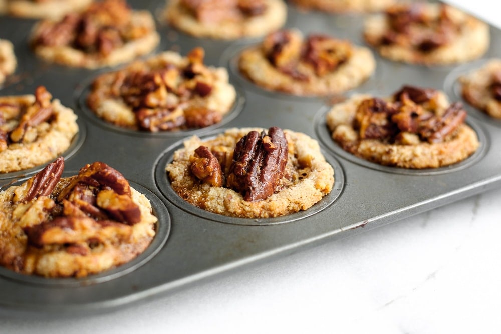 Close up of pecan tarts in a mini muffin tin.