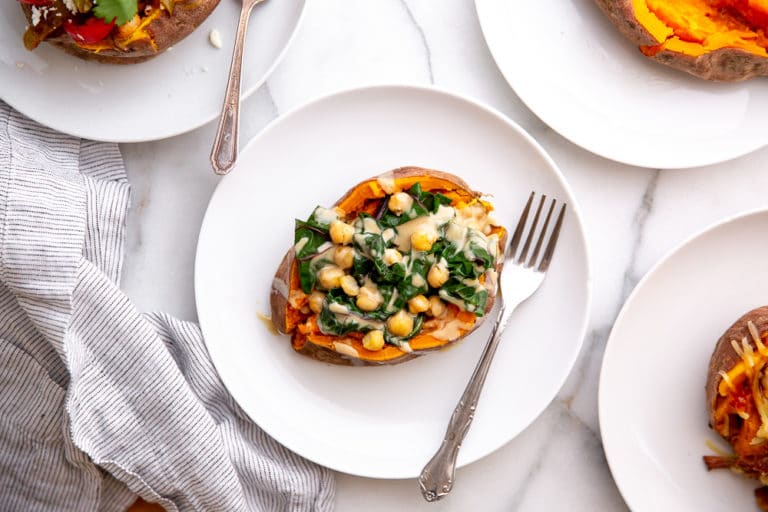 Overhead shot of slow cooker sweet potatoes loaded with different toppings.