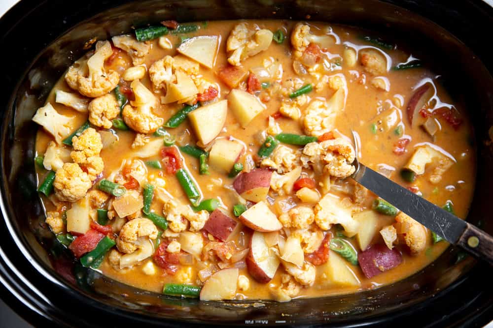 an overhead shot of massaman curry ingredients in a slow cooker