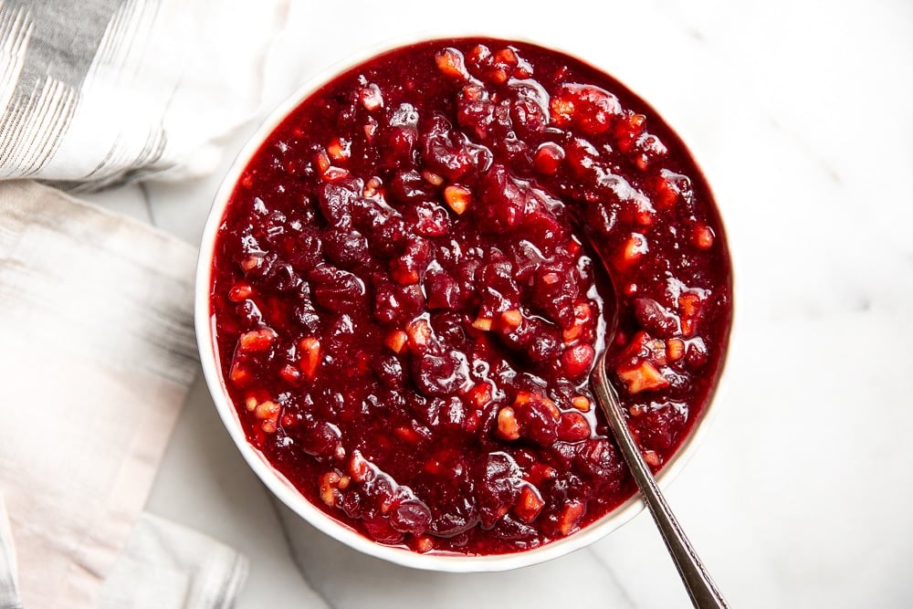 Cranberry sauce in a bowl with a spoon for a gluten free thanksgiving spread.