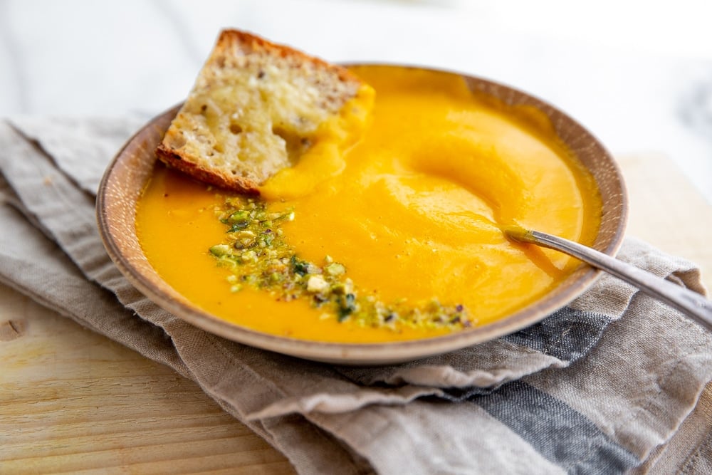 Vegetable potage soup in a bowl with a spoon.