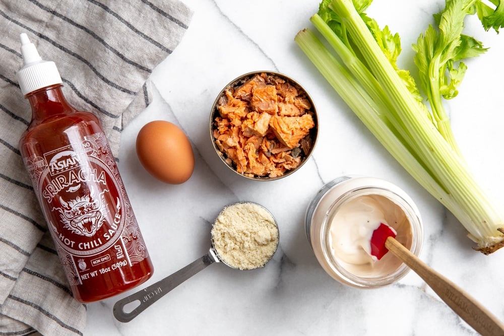 The ingredients to make paleo salmon cakes arranged on a counter. 