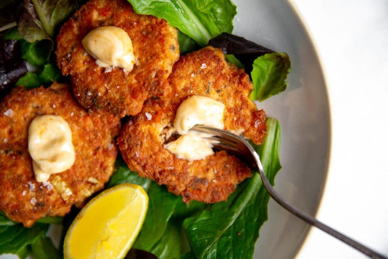 Paleo salmon cakes on a bed of salad greens.