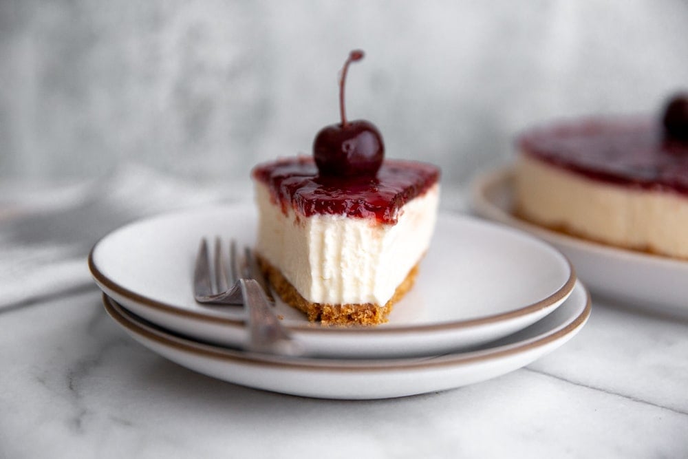 Close-up of a slice of no-bake mascarpone cheesecake on a plate with a fork.