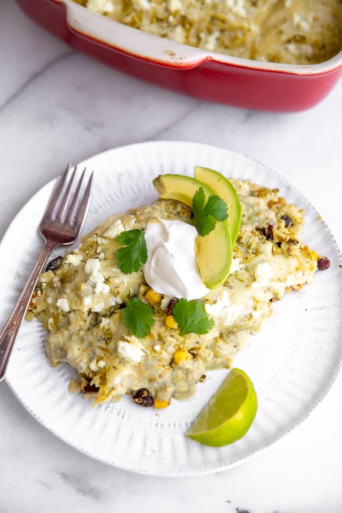 Healthy green salsa enchiladas on a plate with a fork. 