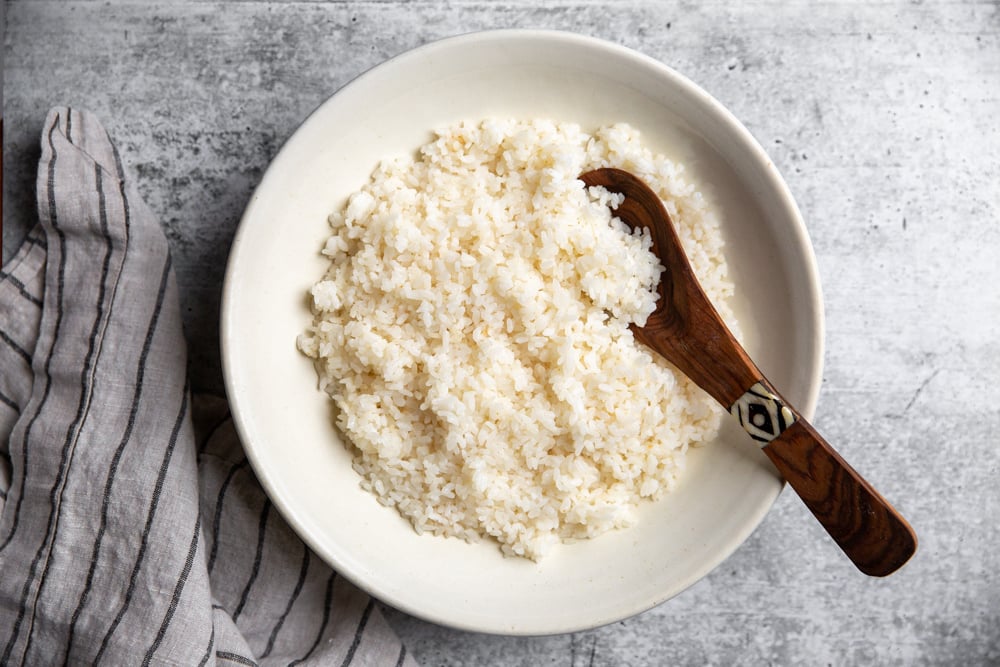 Bowl of sushi rice with a wooden spoon. 