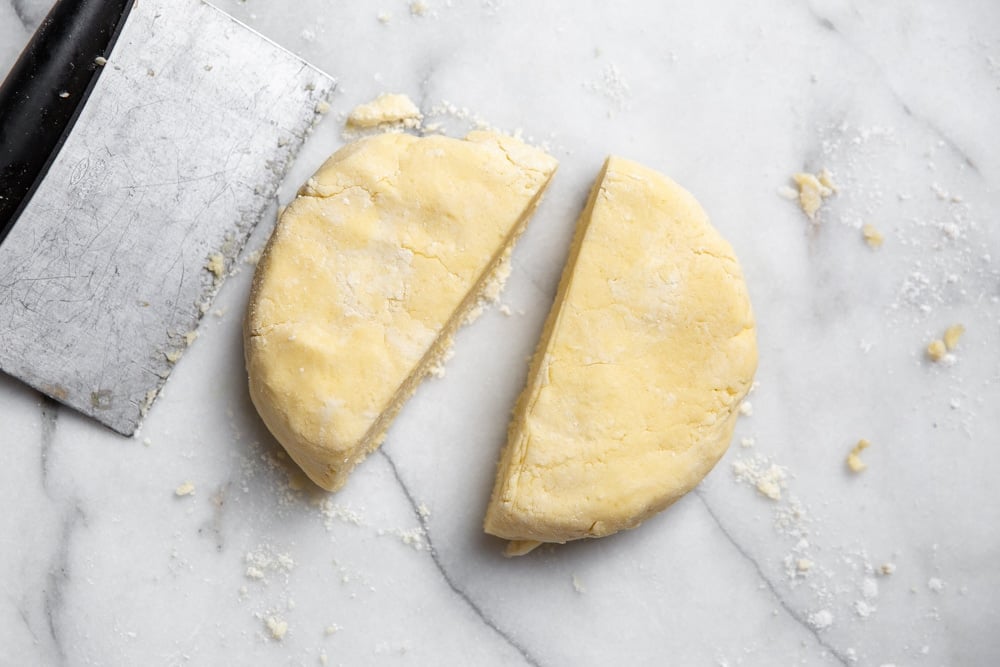 Process shot showing the gluten free pie dough cut into two halves. 