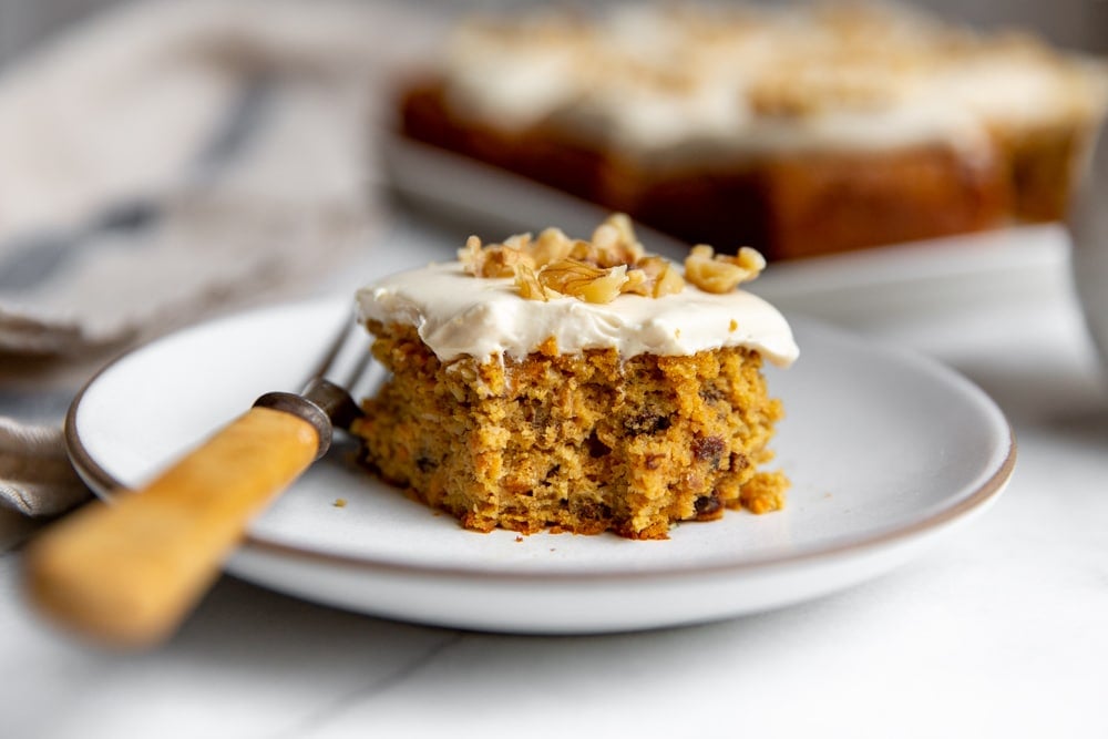 Slice of gluten free carrot cake on a plate with a fork.