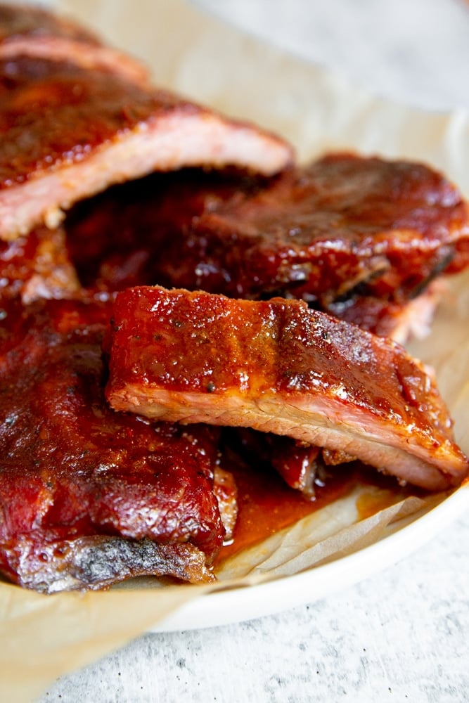 Close up of smoked baby back ribs on a serving platter. 