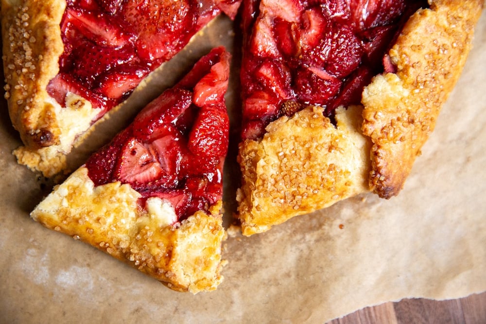 A strawberry galette on a wooden serving board.