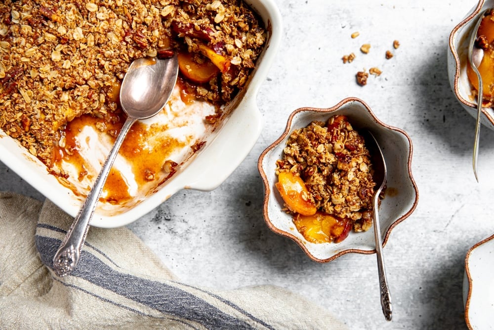 Overhead shot of gluten free peach crisp in serving bowls. 